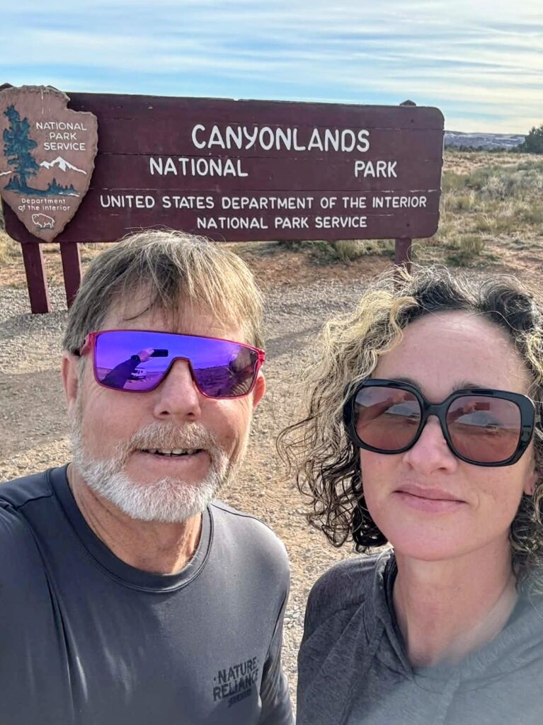 Two people in front of a national park sign